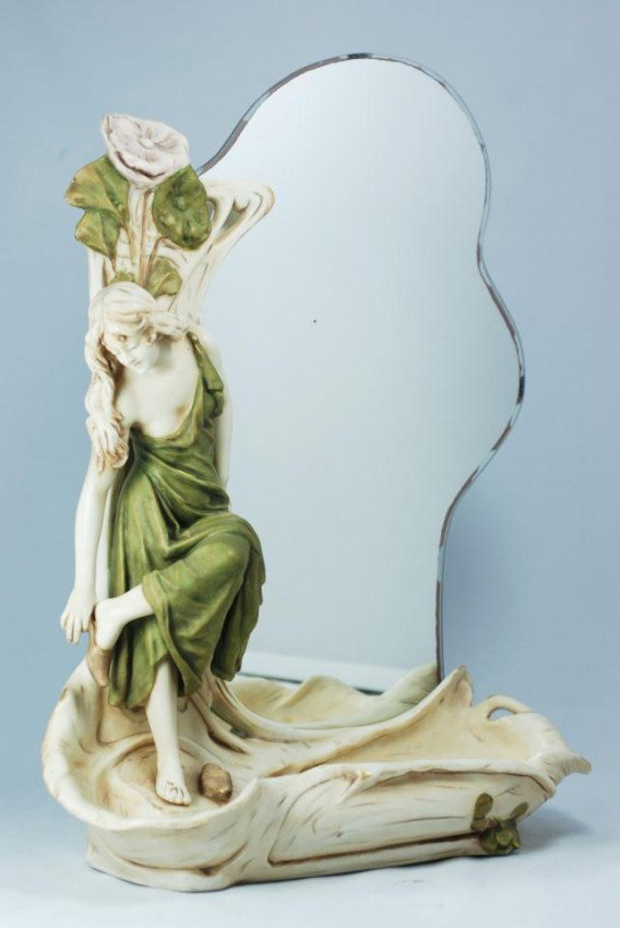 ROYAL DUX FIGURAL VANITY MIRROR w/ BASIN: Depicts a woman removing her shoes as if to step into a pond. Bottom of mirror is wash basin to fill with water. Has pink triangle mark to bottom. Also marked #322. Measures 16 1/4" h X 12 1/4" w.