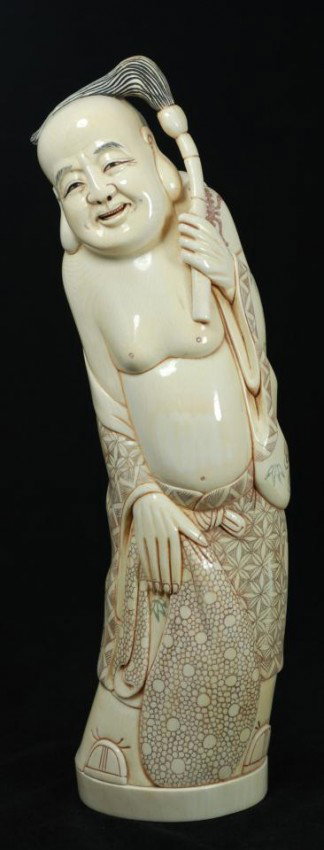 CHINESE CARVED IVORY FIGURE OF BALD MAN: Hand carved Chinese ivory figure depicting Buddha holding a tasseled scepter. In his right hand is a bag. He is wearing layered robe with intricate polychromed flowers, fans, calligraphy, patterns and