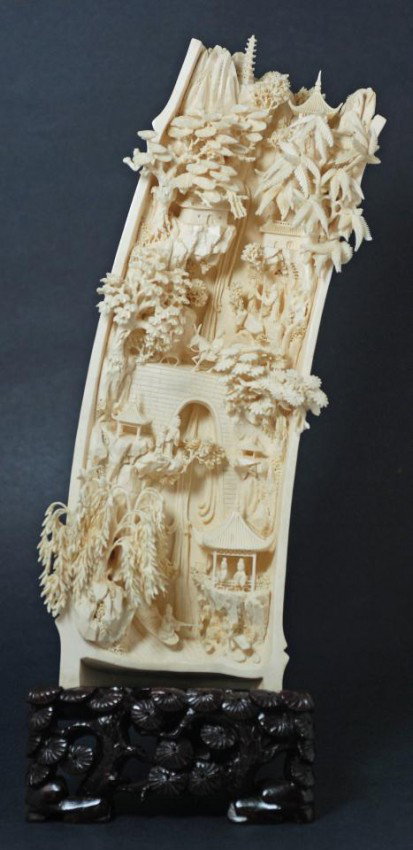 CHINESE CARVED IVORY TUSK VILLAGE SCENE PLAQUE: Chinese carved ivory tusk village scene plaque. Highly detailed village scene depicting a waterfall, bridge, animals, people, pagodas, trees and rocks. Reverse has releif carved scene with birds, bamb