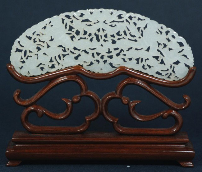 CHINESE CARVED WHITE JADE PLAQUE ON STAND: Chinese white jade hand carved reticulated screen. Depicts bats, children, birds and flowers. Includes fitted wooden stand. Beautiful translucence. Measures 2 3/8" height x 6" width + 3" base (6cm x 1