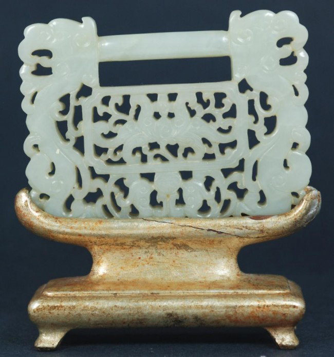 CHINESE CARVED CELADON JADE BELT BUCKLE: Chinese hand carved celadon jade belt buckle . Has a fully reticulated design depicting dragons, bats and Phoenix with a scroll design. Measures 2 3/4" height x 3 3/4" width + 1 3/4" base (6.9cm x 9.5
