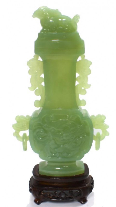 CARVED CELADON JADE URN w/ FOO DOG FINIAL: Hand carved Chinese celadon jade covered urn. Has relief carved dragon design to front Phoenix design to back. Has figural eagle headed beast to cover. Has 4 figural scrolled dragon handles with 2 rel