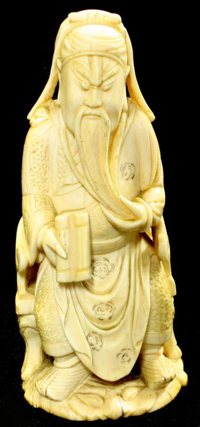 CHINESE CARVED IVORY SITTING WISEMAN FIGURE: Hand carved Chinese wise wan figure. He is sitting while holding a scroll and touching his beard. Intricate etched decoration to layered robe. He is sitting on a chair with figural foo dog face and pa