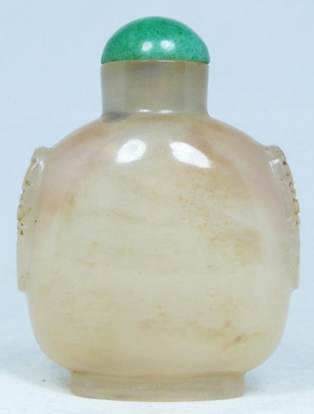 CHINESE CARVED WHITE JADE SNUFF BOTTLE: Chinese hand carved white jade snuff bottle. Has wide form with relief carved dragon heads to sides.. Measures 2 3/4" height (6.9cm). Snuff bottles were used by the Chinese during the Qing Dynasty to