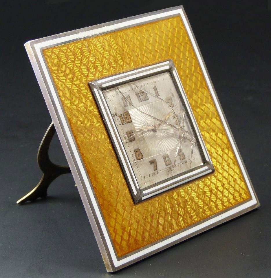 ANTIQUE GENEVA SWISS STERLING GUILLOCHÉ CLOCK: Antique Geneva Clock Company desk clock. Has a yellow guilloche enamel design to border with interlocking diamond design. Has square silvered face with gold numbers and black notches. Has gold hour an
