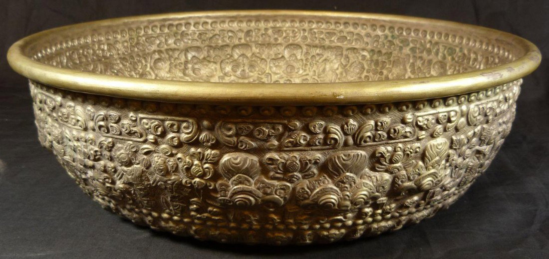 HAND CRAFTED BALINESE SILVER OFFERING BOWL: Repousse silver Balinese offering bowl. Has intricate pattern depicting mythological beasts and figures with scrolled floral design. Circa 1920. Measures 4 3/4" height x 16 1/4" diameter (12cm x 41.2c