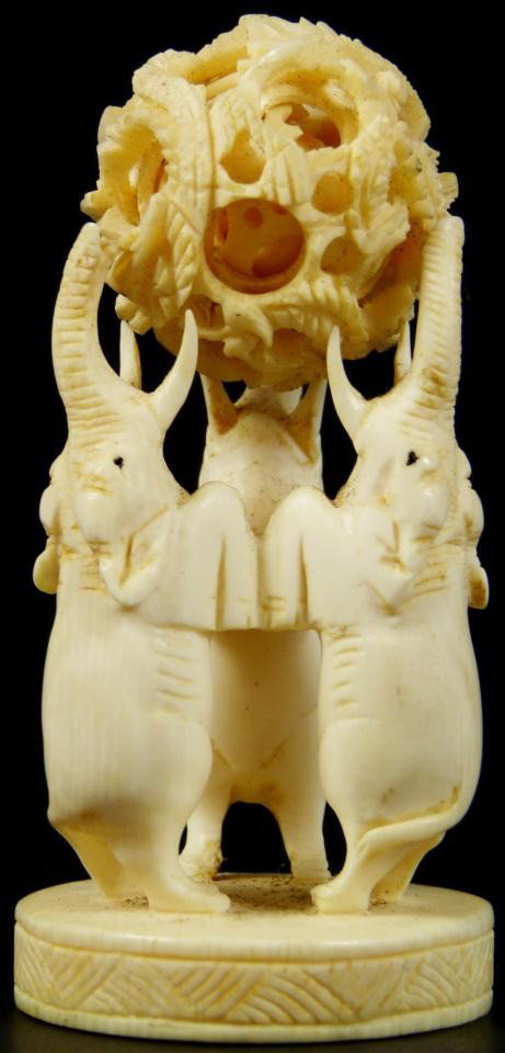 CHINESE IVORY CONCENTRIC BALL & ELEPHANT STAND: Chinese hand carved ivory dragon concentric ball having approximately 6 layers. Has figural three elephant stand with trunks and tusks pointing up. Includes wooden base. Measures 3 1/4" height + 1" ba