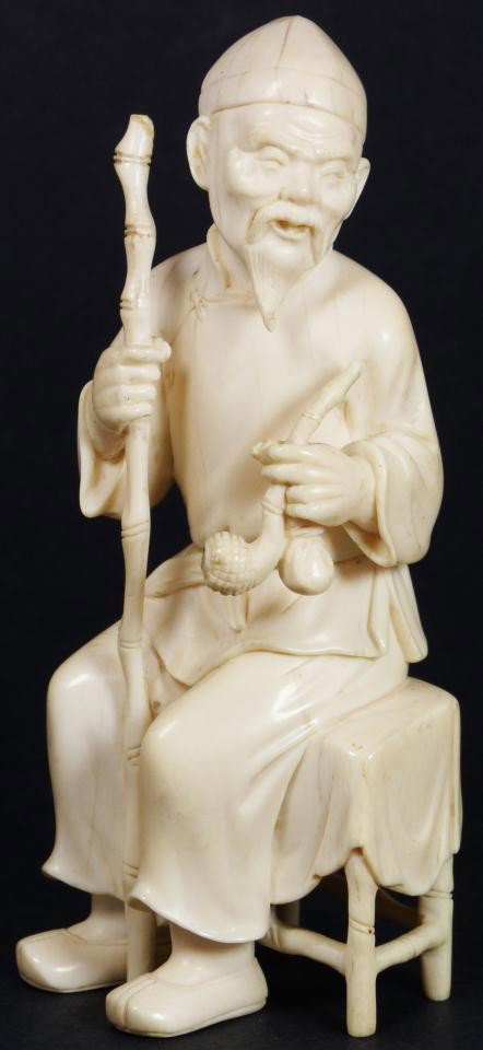 JAPANESE CARVED IVORY MAN w/ PIPE FIGURE: Japanese hand carved ivory figure depicting an old man with tobacco pipe and bag. In his right hand is bamboo staff. He is seated on bamboo stool. Measures 6 1/8" height (15.5cm).