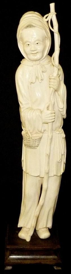 ANTIQUE CHINESE HAND CARVED IVORY FISHERMAN FIGURE: Chinese hand carved ivory figure depicting a fisherman with bamboo fishing pole and basket on right forearm. Has hidden compartment to top of head (see photos). Signed to back of right thigh. Measures