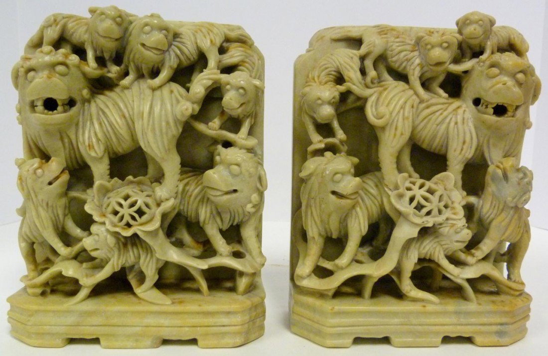 PAIR OF CHINESE SOAPSTONE CARVED BOOK ENDS: Pair of Chinese soapstone relief carved Foo dog book ends. 19th/20th century. Each measures 8" height x 6 1/2" width x 2 3/4" (20.3cm x 16.5cm x 6.9cm).