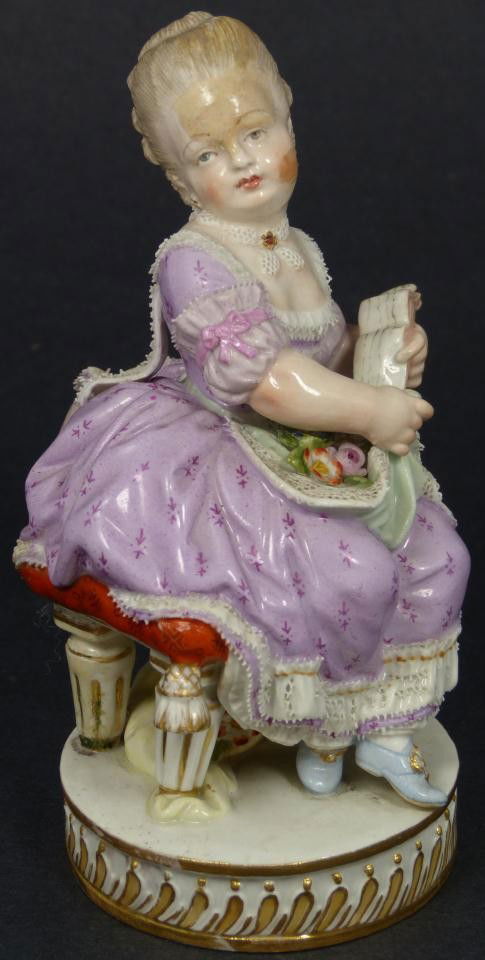 MEISSEN PORCELAIN FIGURE OF YOUNG WOMAN READING: Antique Meissen German porcelain figure depicting a young woman reading. She is sitting in a chair on a pillow. Lacework to woman's dress. Has blue crossed swords mark to bottom. Impressed 122. 19th c
