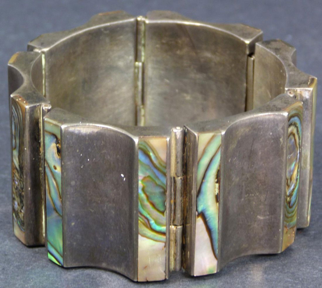 STERLING SILVER TAXCO INLAID ABALONE BRACELET: Beautiful Taxco Sterling Silver Abalone inlay bracelet. Has a half pipe design with inlayed abalone at plateaus. Each link connected by hinge. Marked Taxco 925 and Sterling Hecho En Mexico to inside.