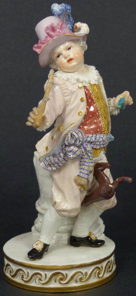 MEISSEN PORCELAIN FIGURE OF BOY WITH TOY HORSE: Antique hand painted Meissen German porcelain figurine. Figure depicts a boy in affluent garb with sash riding a toy horse while standing in front of a column. Blue Meissen crossed swords mark to bott