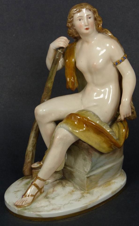 MEISSEN PORCELAIN FIGURE OF HUNTING GODDESS: Antique hand painted Meissen German porcelain figurine. Figure depicts hunting goddess sitting nude female with wooden club and bear skin. Blue Meissen crossed swords mark to bottom with 45 in gold. I