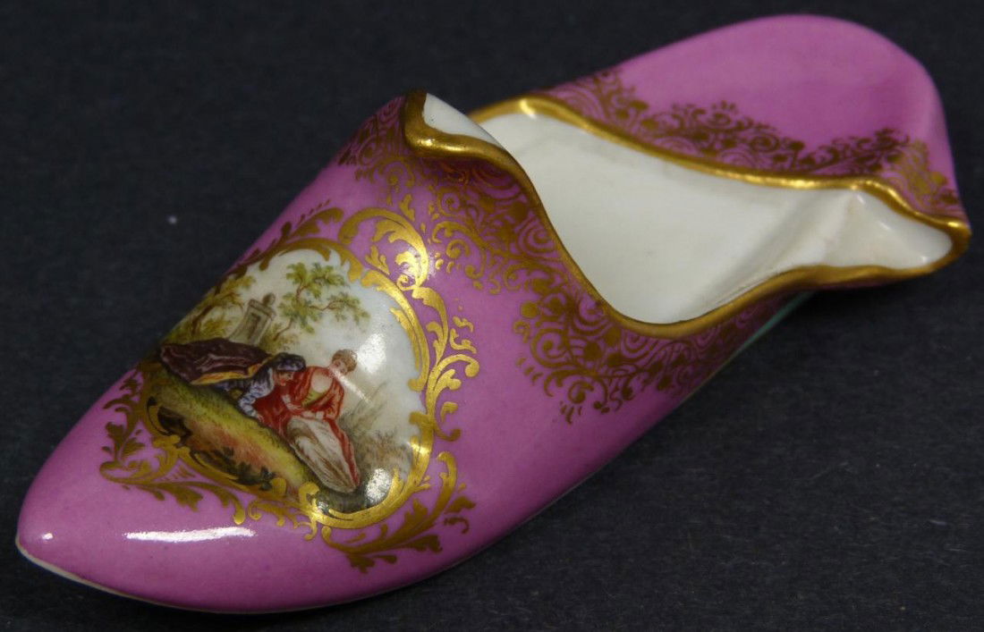 HAND PAINTED MEISSEN PORCELAIN SLIPPER: Antique hand painted German porcelain figural slipper sculpture. Has a hand painted scene depicting a courting couple with gilded highlights over pink background. Blue Crossed swords mark to bottom.