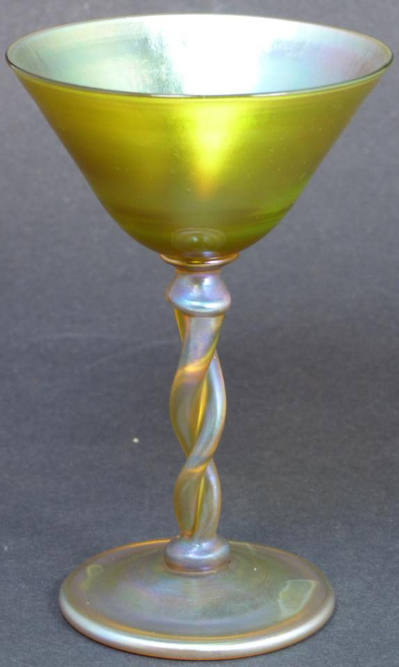 TIFFANY L.C.T. TWISTED STEM FAVRILE MARTINI GLASS: Beautiful Louis Comfort Tiffany iridescent art glass martini glass with twisted stem design. Beautiful yellow and purple color. Marked "L.C.T. R9097" to bottom. Circa 1900. Measures 6" height x 3 7/8"