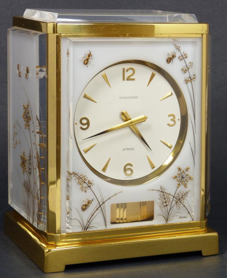 LECOULTRE ATMOS WHITE CARAVELLE MANTLE CLOCK: Jaeger LeCoultre White Caravelle Atmos clock with a honey bee design. Enchanting clock with fitted white leather presentation box. Full working condition. Signed Marina lower right. Circa 1970. Mounte