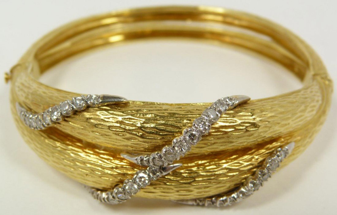 18KT YELLOW GOLD & DIAMOND BANGLE BRACELET: Elegant 18k yellow gold & diamond bangle bracelet. Has a matte finish with double band shape. Has worm design set with 35 round cut white diamonds each approximately .03ct totaling 1.05ctw. Total weig