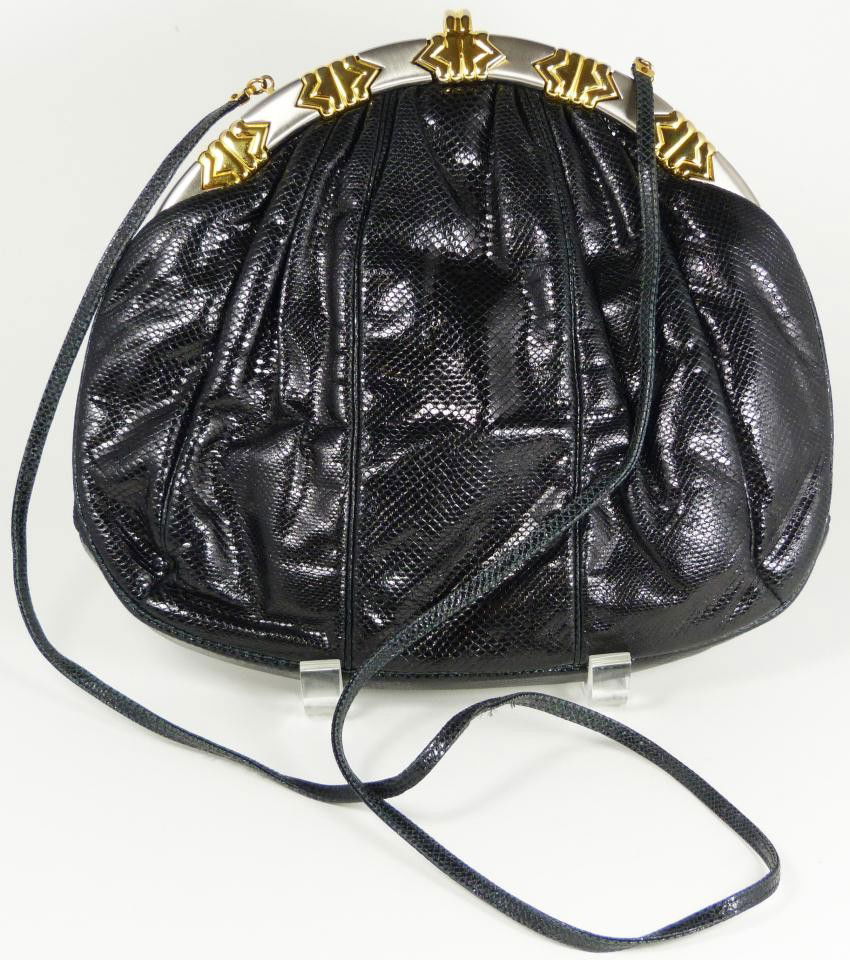 JUDITH LEIBER DESIGNER BLACK SNAKE SKIN PURSE: Judith Leiber designer black snake leather purse. Stunning black design with gold and chrome hardware. Black silk interior with two pockets. One is zippered. Hideaway strap. Measures 9" height x 10" w