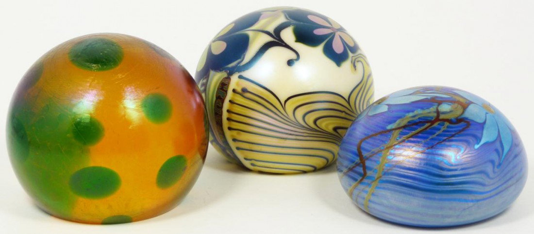 3pc LOT OF IRIDESCENT ART GLASS PAPERWEIGHTS: 3 blown art glass paper weights. Two are Orient and Flume with an iridescent floral design and the other has an amber color with green spots. Largest measures 2 1/2" height x 3 1/4" diameter (6.3cm x 