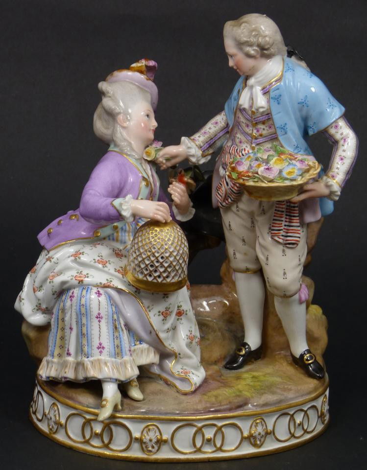 ANTIQUE MEISSEN GERMAN PORCELAIN GROUP FIGURE: Antique Meissen German porcelain group figure depicting a courting a couple. The couple is shown staring intently into each others eyes. The man swooning her with flowers. The woman is sitting with bi