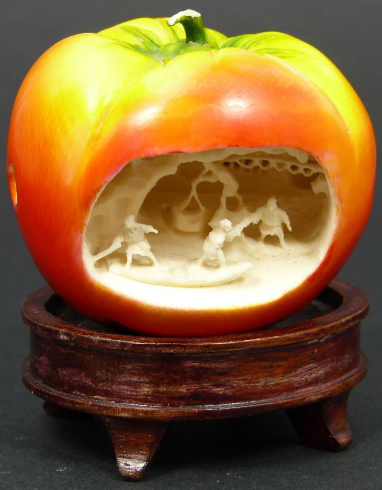 CHINESE RELIEF CARVED IVORY VILLAGE SCENE APPLE: Beautiful Chinese hand carved elephant ivory figural apple with relief carved village scene. Fine detail throughout. Scene depicts villagers in boats and doing various activities. Also in the scene ar