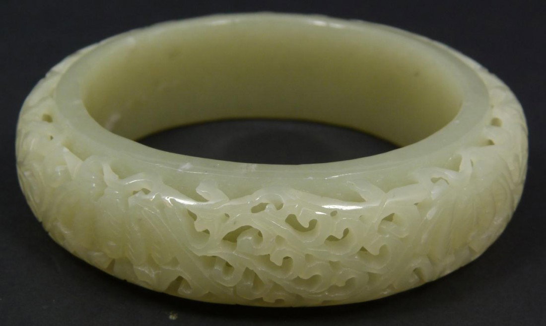 CHINESE FINE RELIEF CARVED JADE BANGLE BRACELET: Finely carved Chinese pale green jade bangle bracelet. Has a layered relief carved scrolled design with 5 bats. Stunning translucence to jade. Measures 3 1/4" diameter (8.2cm). Fits wrist approximatel