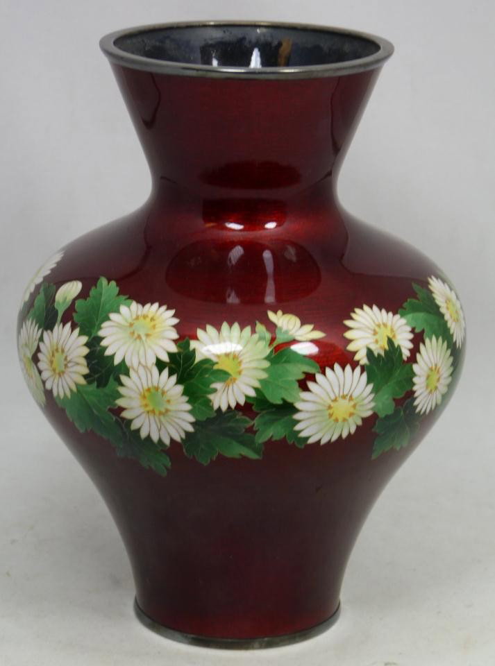 ANDO JUBEI CLOISONNE ENAMLELED SILVER FLORAL VASE: Ando Jubei red enameled cloisonne silver vase. Has obtuse body shape with floral bouquet design over red enamel background. Signed Ando Jubei to bottom. Made circa 1920. Measures 9 1/8" height (23.1cm