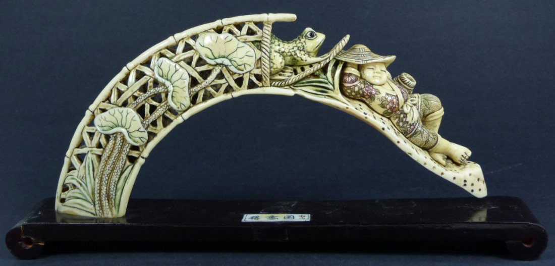 CHINESE CARVED IVORY FROG & SLEEPING BOY TUSK: Hand carved ivory carved polychromed tusk. Fully relief carved design depicting a frog escaping from a trap white the hunter sleeps. Signed to bottom of tusk. Also signed to plaque on fitted base. Mea