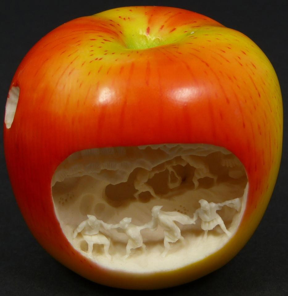 CHINESE RELIEF CARVED IVORY VILLAGE SCENE APPLE: Fabulous Chinese hand carved elephant ivory figural polychromed apple with relief carved village scene. Beautiful red and yellow coloring to exterior. Fine detail throughout. Scene depicts villagers d