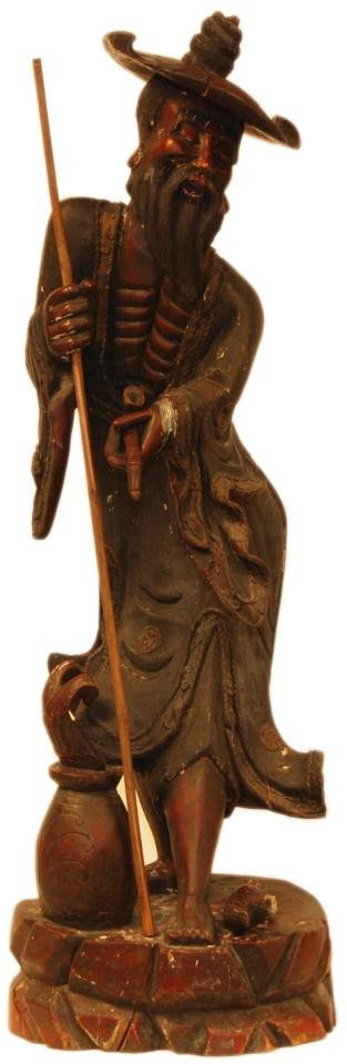 PALATIAL WOOD CARVING OF ELDERLY MAN: Large antique hand carved wooden figure depicting an elderly fisherman. He is holding a bamboo pole in his right hand and a pipe in his left hand. Masterfully carved with relief carving throughout. At