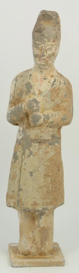 T'ANG DYNASTY CHINESE POTTERY FIGURE OF GROON: T'ang Dynasty polychromed terracotta pottery figure depicting groon with hands fisted to right abdomen. Measures 12 1/2" height (31.7cm). Total weight of 908 grams.
