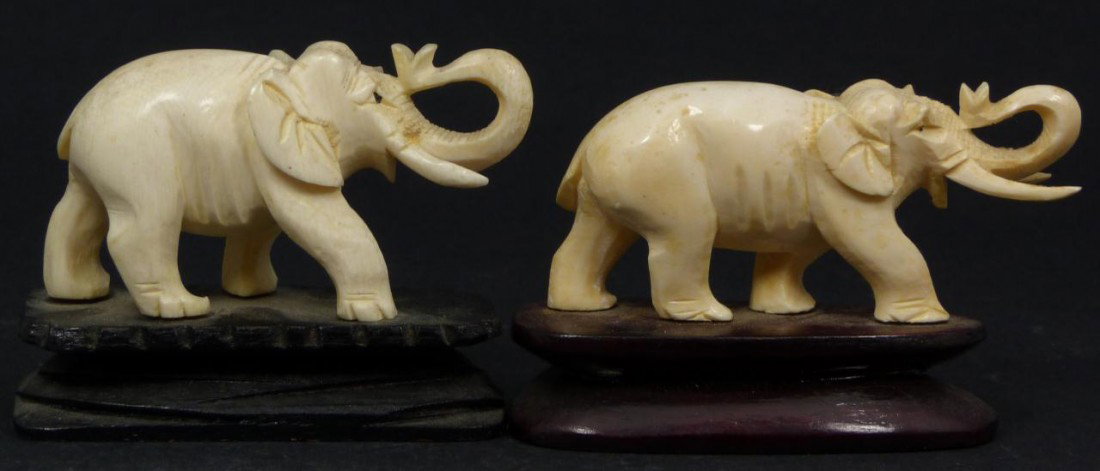 PAIR OF CHINESE CARVED IVORY ELEPHANT FIGURES: Pair of Chinese hand carved ivory figures depicting elephants with tusks and trunks up. Figures mounted on wooden bases. Each measures approx. 1 1/2" height + 3/4" base height (3.8cm + 1.9cm). Total w