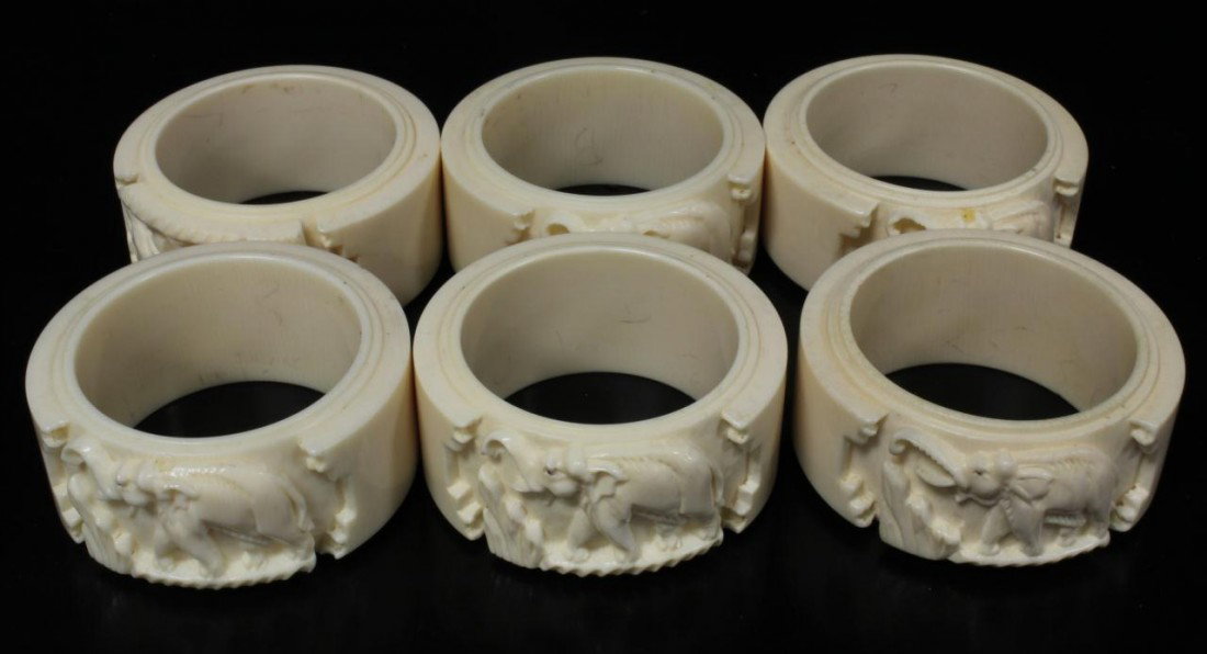 6 CHINESE CARVED IVORY ELEPHANT NAPKIN RINGS: 6 Chinese relief carved ivory napkin rings depicting elephants with trunks up and grass. Each approximately 2 1/8" diameter x 1" depth (5.4cm x 2.5cm).