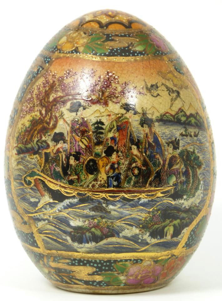 HAND PAINTED JAPANESE SATSUMA MAIDENS EGG: Satsuma porcelain hand painted egg. Depicts a dragon boat scene with numerous maidens. Measures 4 1/4" height x 4" width (10.8cm x 10.1cm).