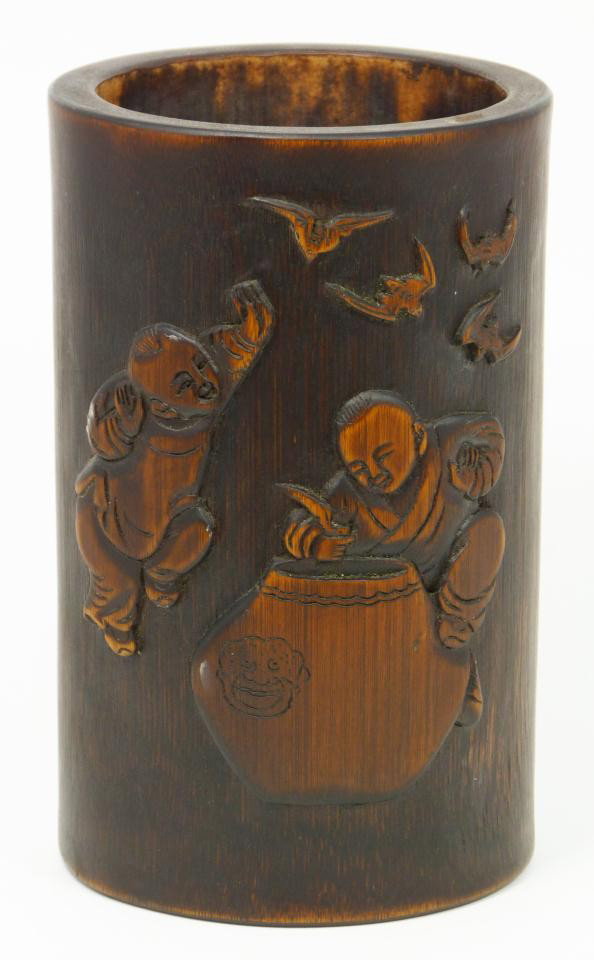 ANTIUE CHINESE HAND CARVED WOODEN BRUSH POT: Antique Chinese relief carved bamboo wood brush pot. Has a masterfully carved design depicting two children cooking in a pot with bats flying above them. To the reverse is calligraphy. 19th century. M