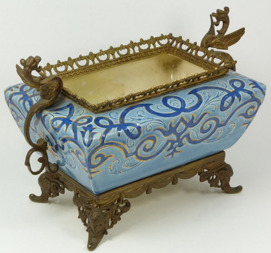 VILLEROY & BOCH PORCELAIN BASKET 19th C: Porcelain basket by Villeroy and Boch of Mettlach in powder blue, navy and gilt scrolling pattern with bronze gallery, flanking winged dragons and resting stand with draping apron and elephant feet. D