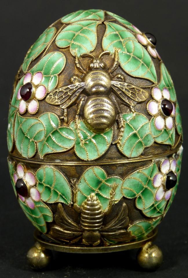 RUSSIAN SILVER ENAMELED INSECTS EGG w STAND: Russian silver enameled egg box having floral design throughout with raised gold wash flies and bees. Has enameled leaves and flowers. Has 8 cabochon cut rubies set throughout. Gold wash interior. Hol
