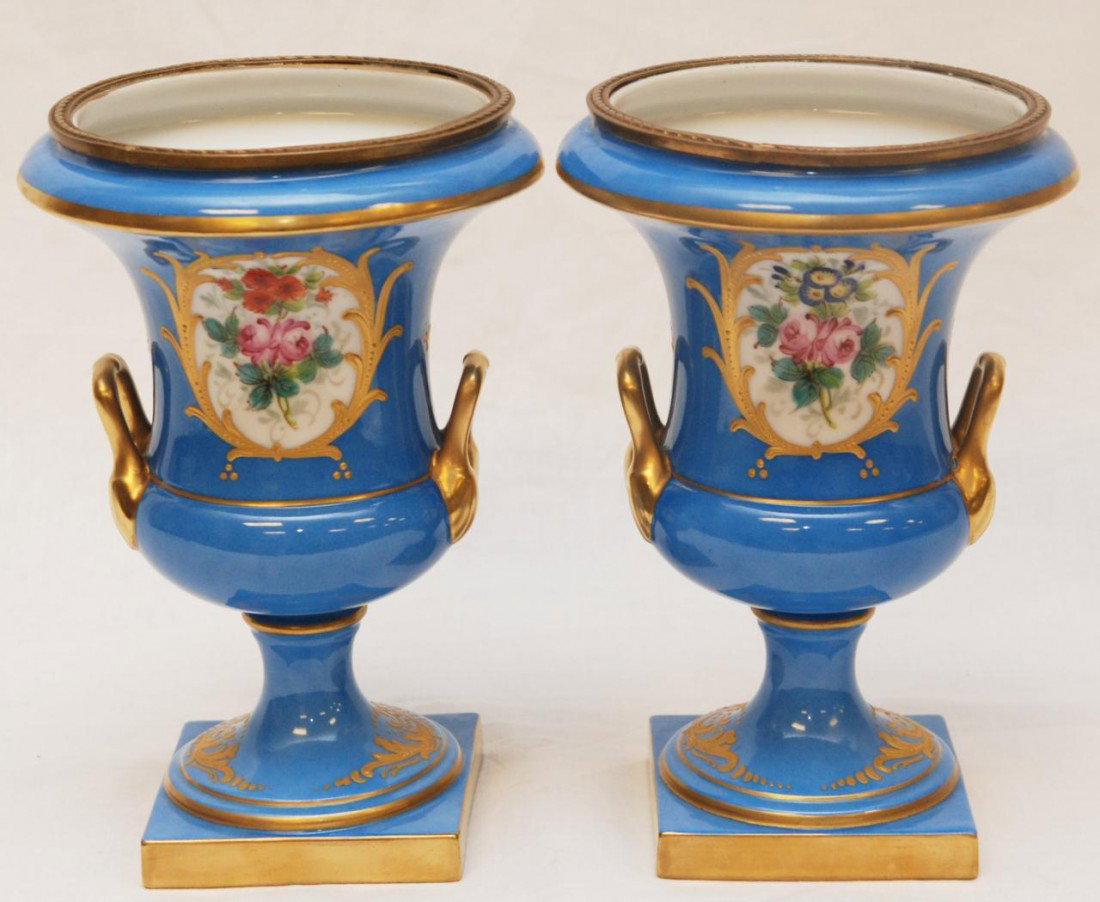Pr SEVRES FRENCH PORCELAIN HANDLED FLORAL URNS: Pair of exquisite hand painted and gilded floral handled urns. Each masterfully crafted with Dore bronze rim. Has blue Sevres mark with M to bottom. 19th century. Measures 8 5/8" height (21.9cm).