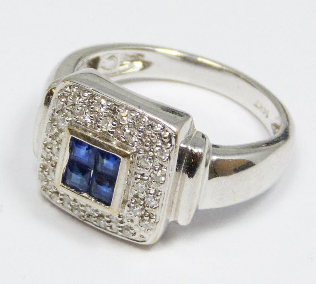 14K WHITE GOLD DIAMOND AND SAPPHIRE RING: 14kt white gold, diamond and sapphire ring. Has four emerald cut sapphires to center surrounded by round cut white diamonds. Ring size 6.75. Total weight of 3dwt / 4.7 grams.