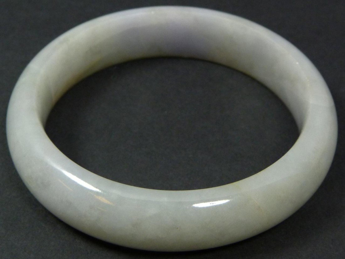 CHINESE HAND CARVED JADEITE BANGLE BRACELET: Hand carved Chinese jadeite bangle bracelet. Beautiful high quality mottled jade with white, pale green and russet colors. Measures 2 7/8" diameter (7.3cm). Fits wrist approximately 2 1/4" diameter (5