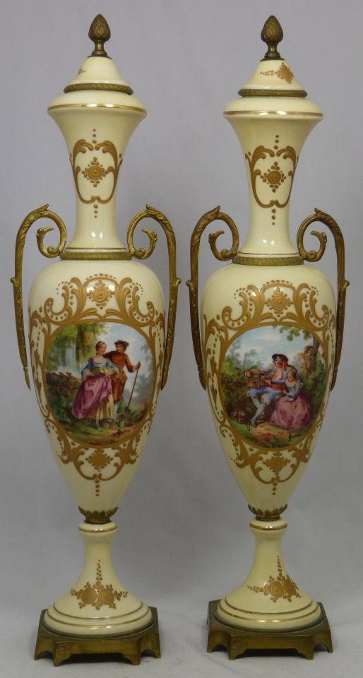 Pr OF ANTIQUE FRENCH PORCELAIN & DORE BRONZE URNS: Pair of antique French porcelain urns clad with Dore bronze bands and bases. Each has a scene depicting courting couples. Each scene is embellished with hand painting and signed lower right "Jean". Ea