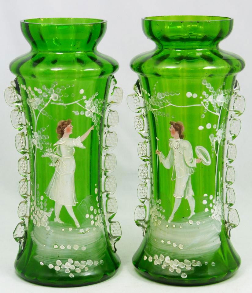 Pr MARY GREGORY STYLE ENAMELED GREEN GLASS VASES: Pair of green art glass enameled vases in the style of Mary Gregory. Each is hand painted and enameled depicting a young woman on one and a courting male with cane and hat next to tree on the other. E