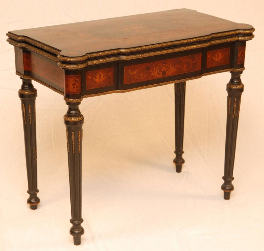 ANTIQUE FRENCH EBONY WOODEN INLAY FLOLDING TABLE: Antique French hand crafted Ebonized wooden folding card table with intricate wooden scroll inlay. Clad with stylized leaf bronze bordering throughout. 18th/19th century. Measures 29" height x 34" wid