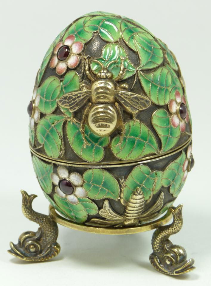 RUSSIAN SILVER ENAMELED INSECTS EGG w STAND: Russian silver enameled egg box having flower and leaf design throughout with raised gold wash flies and bees. Has enameled leaves and flowers. Has 8 cabochon cut ruby jewels set throughout. Gold wash