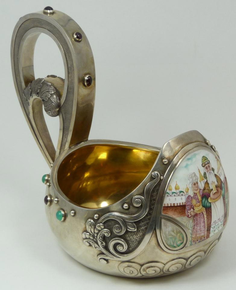 ANTIQUE RUSSIAN SILVER & ENAMEL KOVSH KURLIUKOV: Has the Moscow town mark. Made Circa 1900. Has beautiful enamel miniature depicting a man & woman presenting items with buildings in the background. Decorated throughout with set cabochon ruby and eme