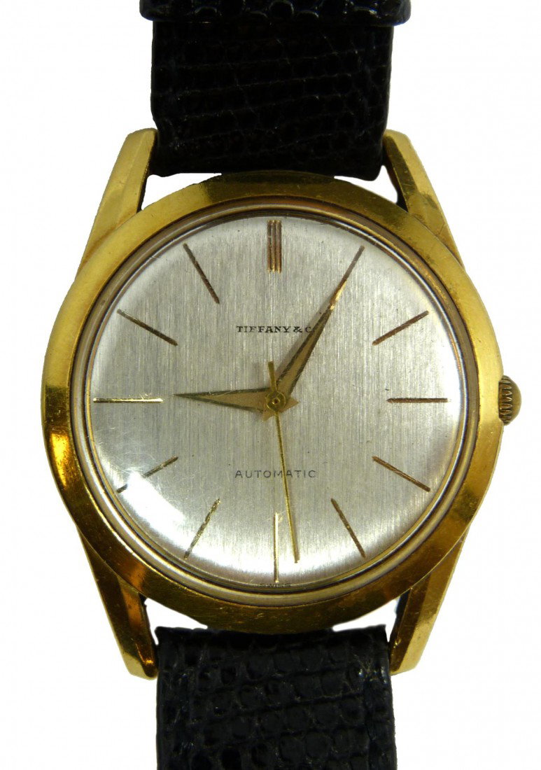 TIFFANY & Co 18K GOLD WATCH w BLACK LIZARD BAND: Tiffany & Company Swiss 18k yellow gold Watch. Has silvered face with gold notches. Gold hour, minute and second hands. Has black lizard band. Back of case marked 1935514 and 10364-21. Case approx. 1 