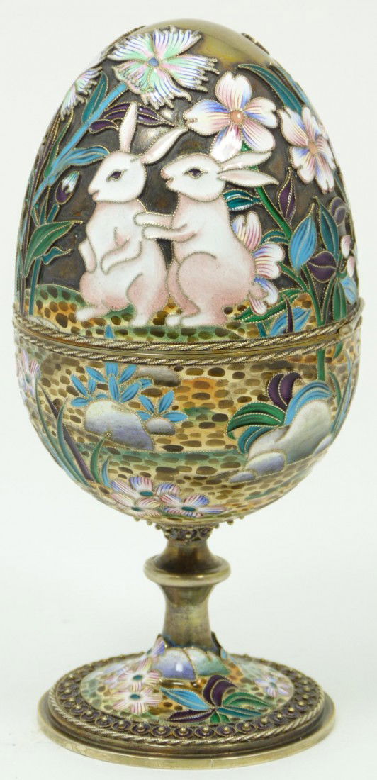 IMPERIAL RUSSIAN SILVER ENAMELED EGG OVCHINNIIKOV: Russian silver enameled hinged egg box depicting rabbits with flowers. Gold wash interior. Piece holds Cyrillic Pavel Akimov Ovchinnikov workmaster marks. Holds 84 silver purity mark with town mark an