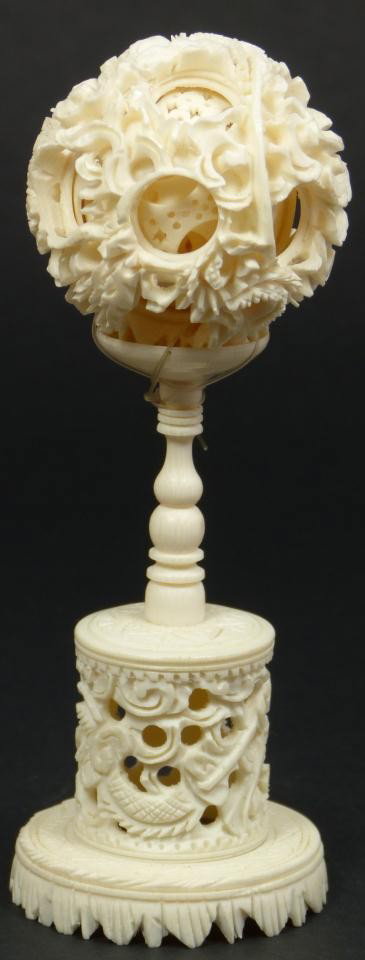 CHINESE IVORY DRAGONS CONCENTRIC BALL & STAND: Chinese hand carved ivory concentric ball having reticulated dragon design throughout. Approx. 8 layers. 20th Century. Measures 5 5/8" height (14.2cm). Total weight of 77 grams.