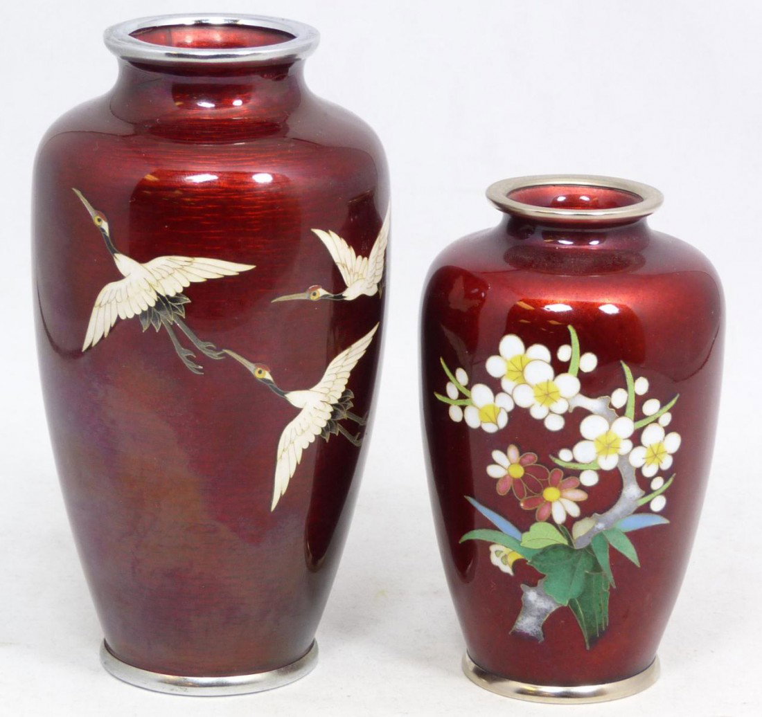2 ANDO JUBEI JAPANESE ENAMELED SILVER VASES: Two Japanese Ando Jubei red enameled cloisonne silver vases. One has a design depicting flying storks and the other has a floral design. Each signed Ando Jubei to bottom. Both circa 1920. Largest meas